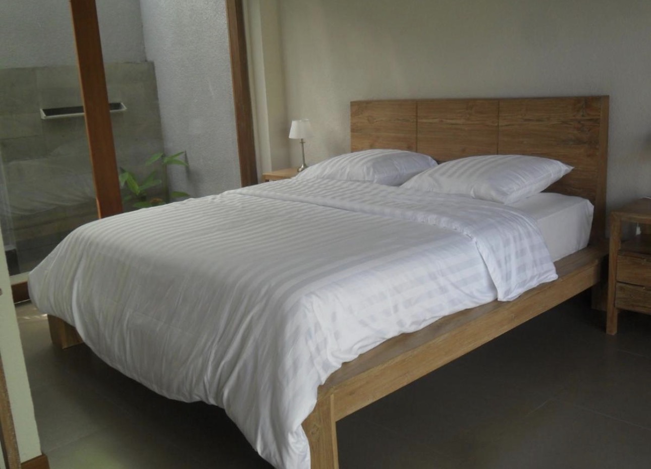 Habitación con cama de madera y puerta a ducha exterior