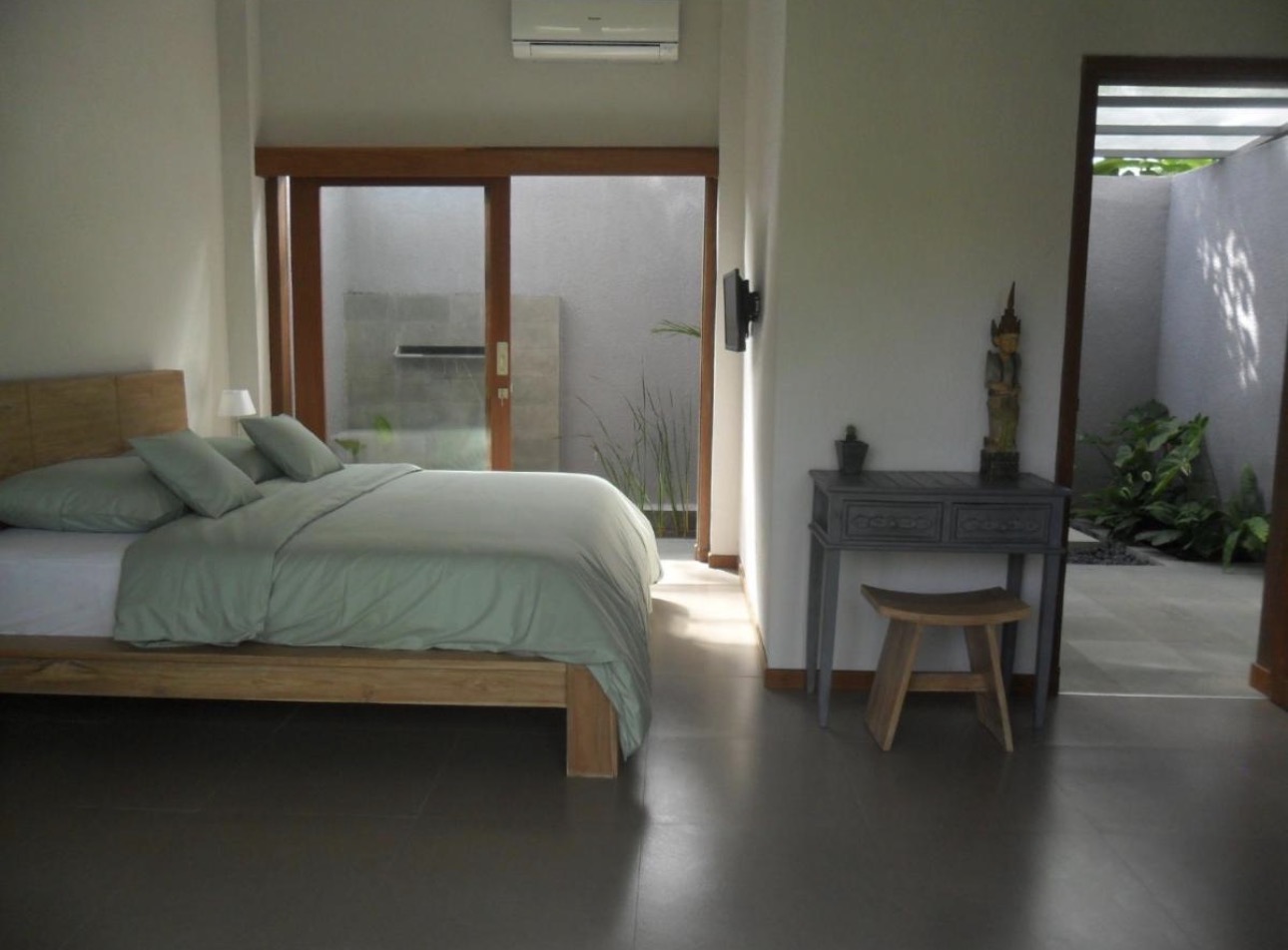 Habitación con ropa de cama verde salvia y patio interior