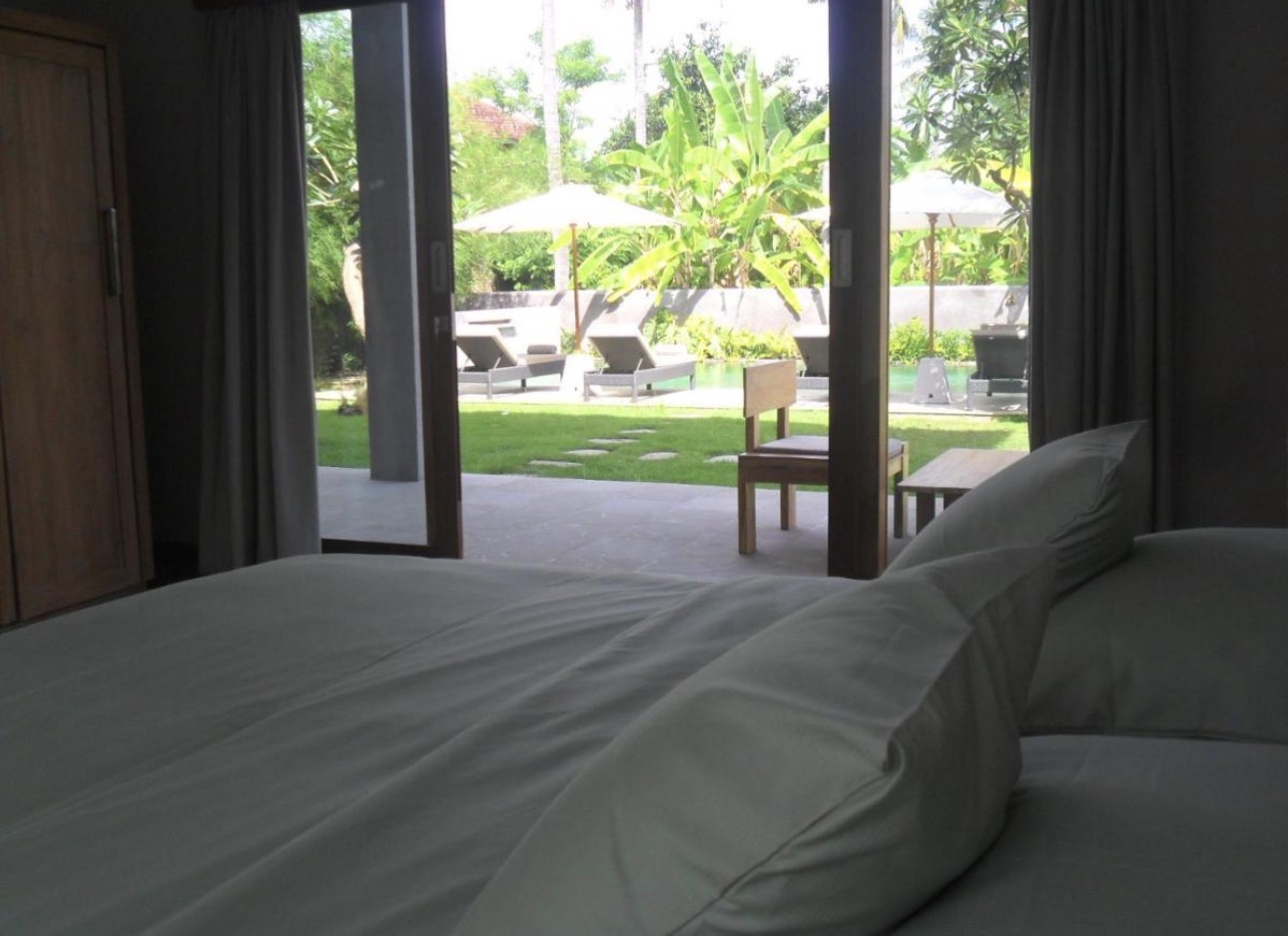 Vista desde la cama hacia el jardín y la piscina